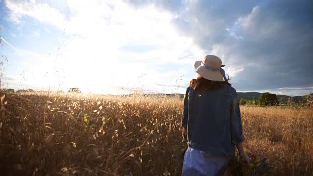 拿着花篮的女人走过麦田视频素材