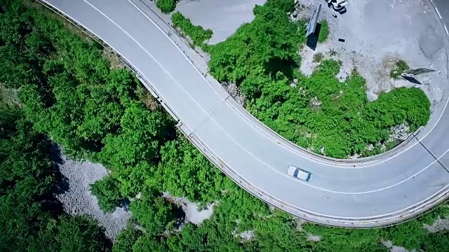 鸟瞰图一个弯曲的道路与汽车通过。山路视频素材