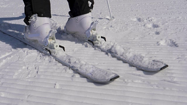 在一个阳光明媚的日子里，滑雪者踩进滑雪绑定与他的滑雪靴视频素材