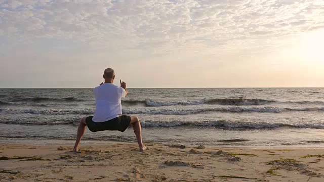 夕阳西下时，站在海边练习亚洲武术的人视频素材