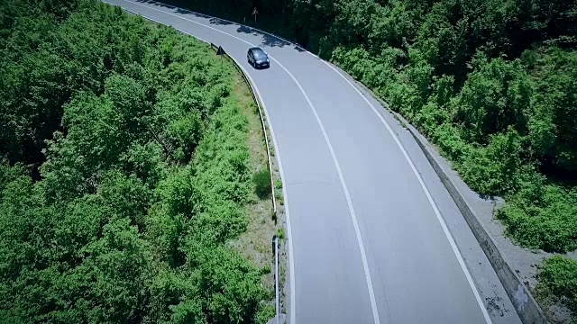 鸟瞰图一个弯曲的道路与汽车通过。山路视频素材