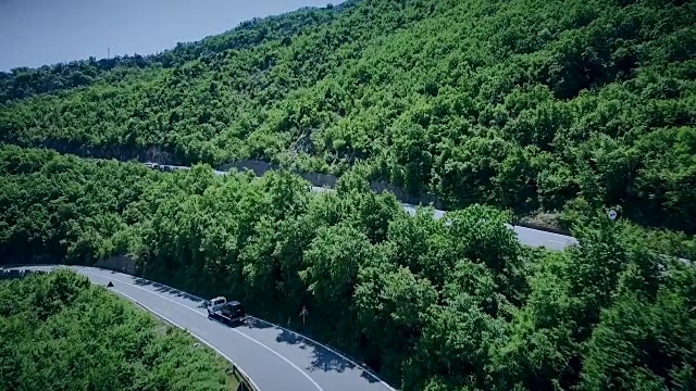 鸟瞰图一个弯曲的道路与汽车通过。山路视频素材