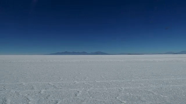 南美玻利维亚的场景:卡车穿过盐沼的慢镜头视频素材