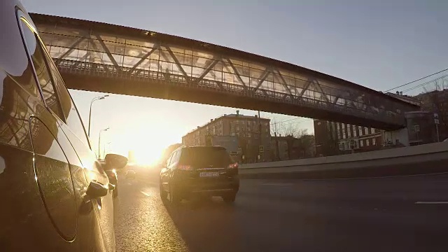 汽车在城市的高速公路上缓缓行驶，夕阳西下视频素材