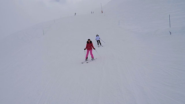 冬天浓雾中，滑雪者在山坡上滑雪视频素材