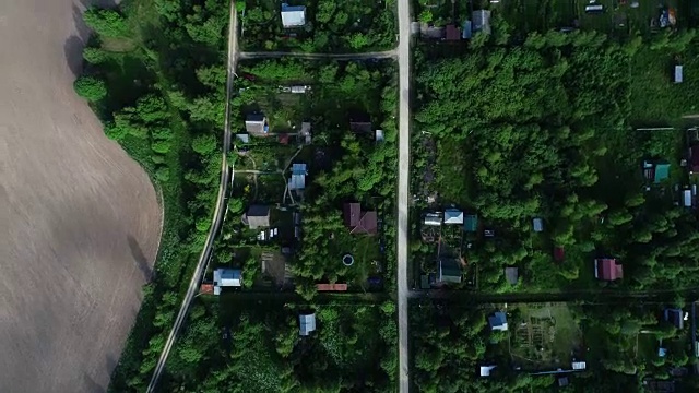 村里的路。汽车沿着树木和房屋之间的道路行驶。视频素材