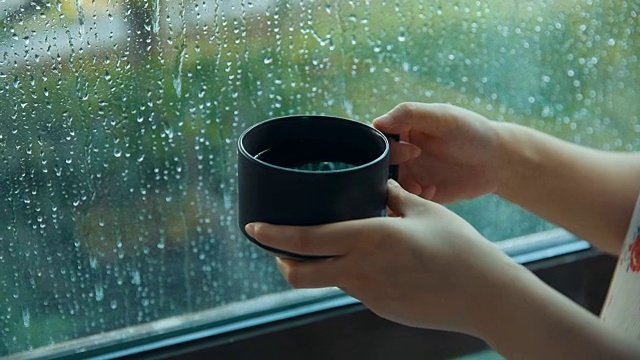 下雨天靠窗喝咖啡的女人视频素材