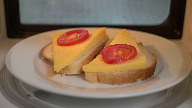 用微波炉加热食物。在烤箱里用融化的奶酪做三明治视频素材