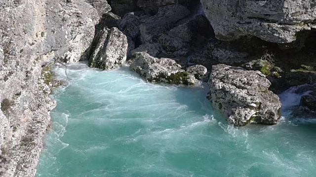 水在石头间流动。清澈的水迅速落下，在石头周围流动。视频素材