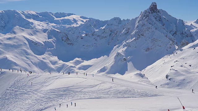 山上的晴天滑雪胜地的许多滑雪者在斜坡上视频素材