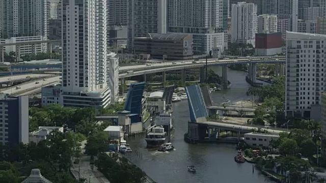 在迈阿密市中心的迈阿密河上，一艘货轮正在通过巴克尔桥视频素材