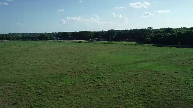 飞过一片开阔的田野，飞向德克萨斯州科西卡纳的一所农舍视频素材