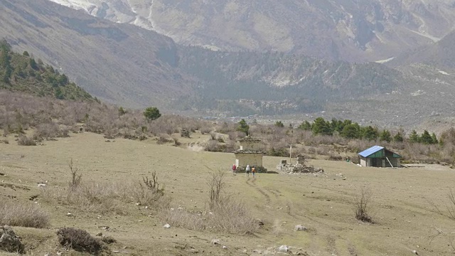 导游带领的游客正在尼泊尔马纳斯鲁地区的喜马拉雅山徒步旅行。视频素材