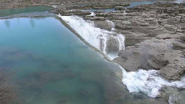 水沿瀑布而下。大量的水从岩石边缘落下。视频素材