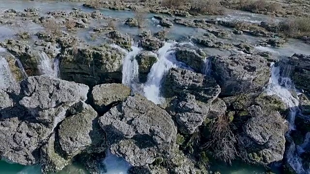 水沿瀑布而下。大量的水从岩石边缘落下。视频素材