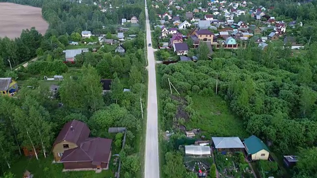 村里的路。汽车沿着树木和房屋之间的道路行驶。视频素材