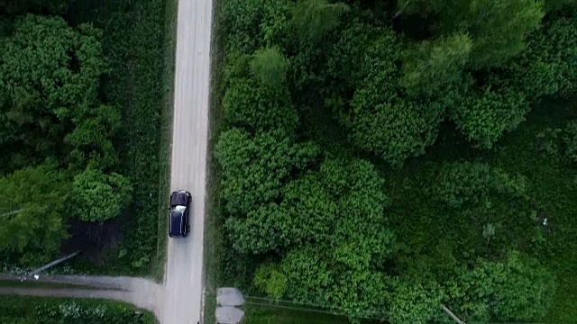 村里的路。汽车沿着树木和房屋之间的道路行驶。视频素材