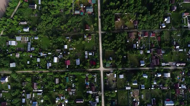 村里的路。汽车沿着树木和房屋之间的道路行驶。视频素材