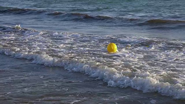 黄色浮标在海水中缓慢移动。浮在水波上的海上浮标。视频素材