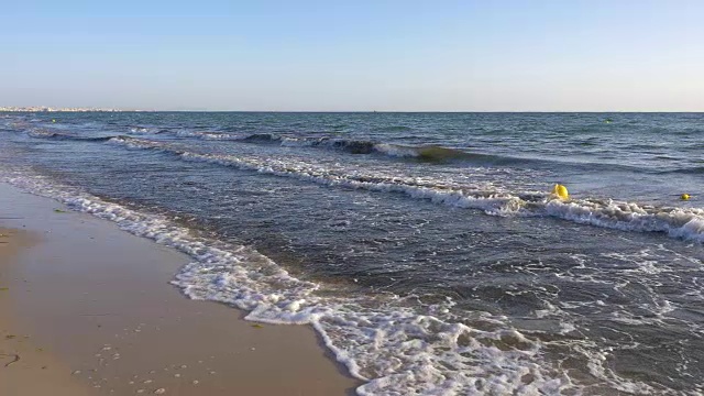 在海滩的深水中漂浮的黄色浮标慢镜头视频素材