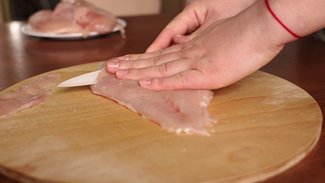 女厨师在木板上切生鸡肉。视频素材