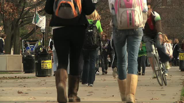 一大群学生在美国密歇根大学安娜堡校区的公园里散步视频素材