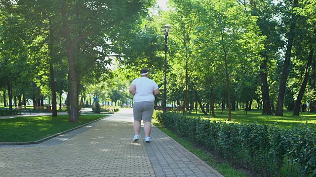 胖子在公园慢跑，减肥计划开始，健康的生活方式视频素材