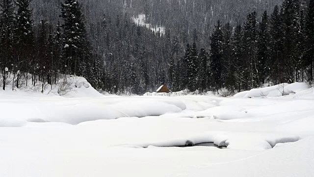 下雪的时候，山上河边的一所房子。视频素材