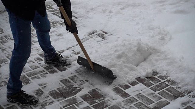 那个不知名的人清扫街上的积雪。缓慢的运动。视频素材