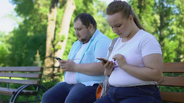 一对肥胖的夫妇在社交网络上发照片，沮丧的女孩等待点赞视频素材