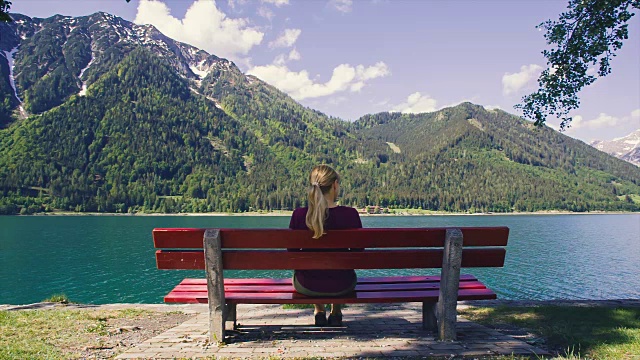 独自坐在椅子上的女孩看风景观光山湖风景。视频素材