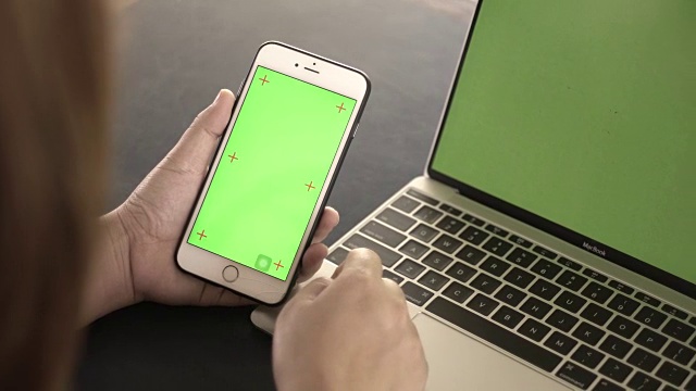 库珀:一名女子正在看绿色屏幕的智能手机视频素材