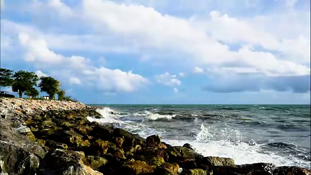 夏天，海浪把海水冲到岩石滩上。近距离观察海浪拍打海滩，计时圈视频素材