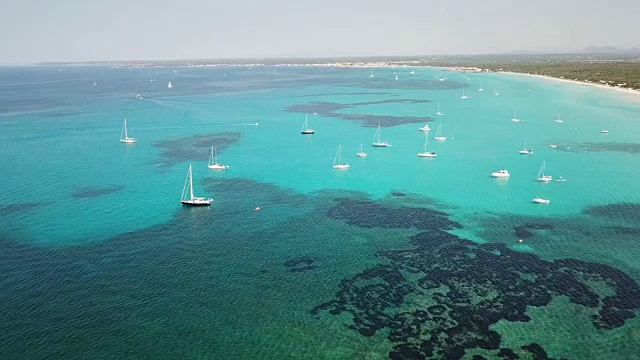 令人惊叹的无人机空中景观迷人的海滩Es Trencs和船与绿松石海。它赢得了马略卡岛加勒比海滩的美誉。西班牙视频素材