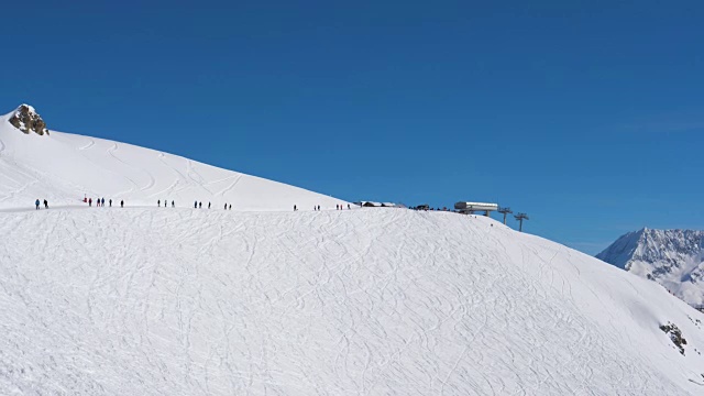 山上的晴天滑雪胜地的许多滑雪者在斜坡上视频素材