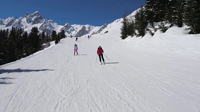 两名女子滑雪者在靠近的山坡上雕刻式滑雪视频素材