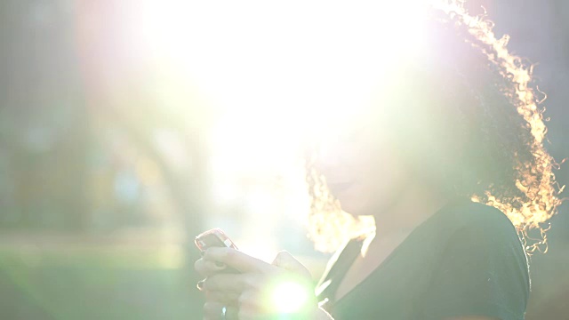 美丽的卷发女人使用手机视频素材