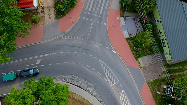 单辆黑色轿车带着拖车行驶在城市的十字路口，鸟瞰图视频下载