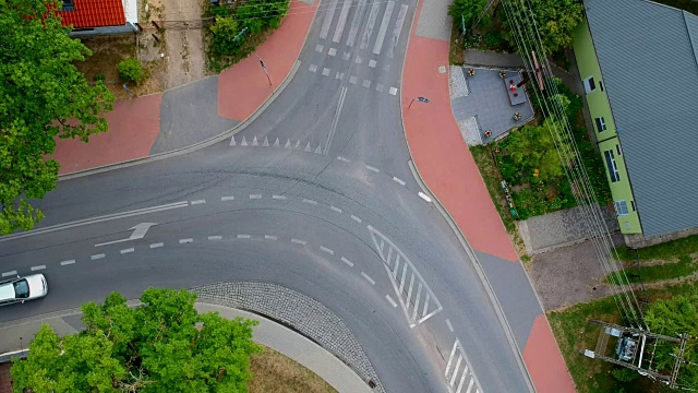 一辆白色轿车正行驶在城市的十字路口，鸟瞰图视频素材