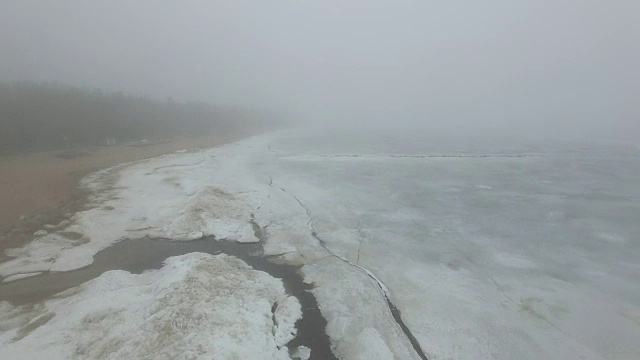 孤独的人走过冰天雪地的海岸线视频素材