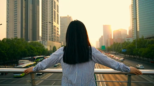 女人看着美丽的城市日落视频素材