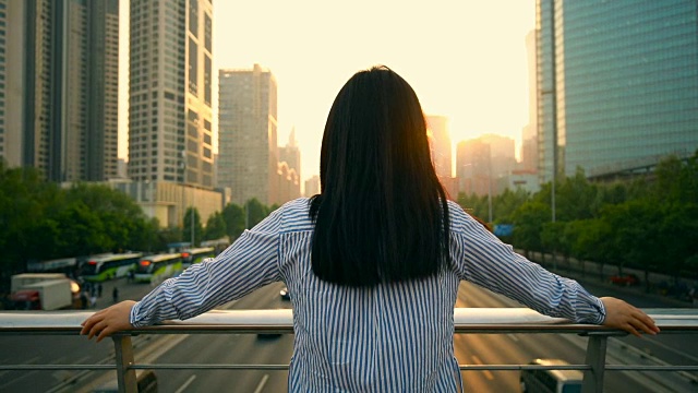 女人看着美丽的城市日落视频素材