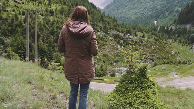 一位年轻的女性徒步旅行者带着照相机爬山。罗马尼亚喀尔巴阡山脉的transagarasan视频素材