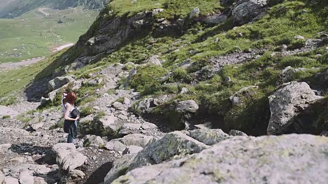 一位年轻的女性徒步旅行者带着照相机爬山。罗马尼亚喀尔巴阡山脉的transagarasan视频素材