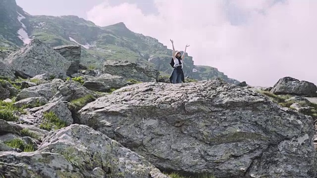 一位年轻的女性徒步旅行者带着照相机爬山。罗马尼亚喀尔巴阡山脉的transagarasan视频素材