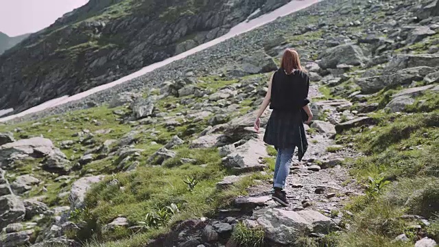 一位年轻的女性徒步旅行者带着照相机爬山。罗马尼亚喀尔巴阡山脉的transagarasan视频素材