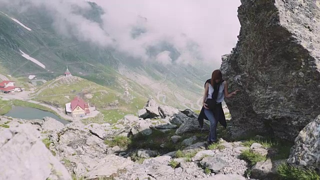 一位年轻的女性徒步旅行者带着照相机爬山。罗马尼亚喀尔巴阡山脉的transagarasan视频素材