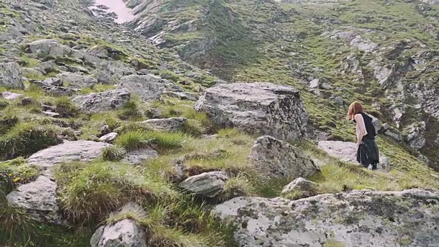 一位年轻的女性徒步旅行者带着照相机爬山。罗马尼亚喀尔巴阡山脉的transagarasan视频素材