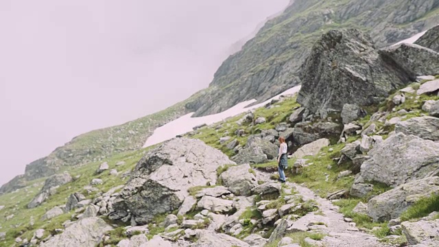 一位年轻的女性徒步旅行者带着照相机爬山。罗马尼亚喀尔巴阡山脉的transagarasan视频素材