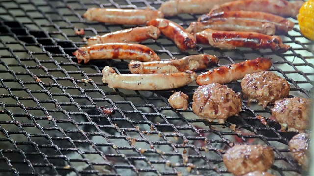 烹饪烧烤香肠和牛肉汉堡。视频下载